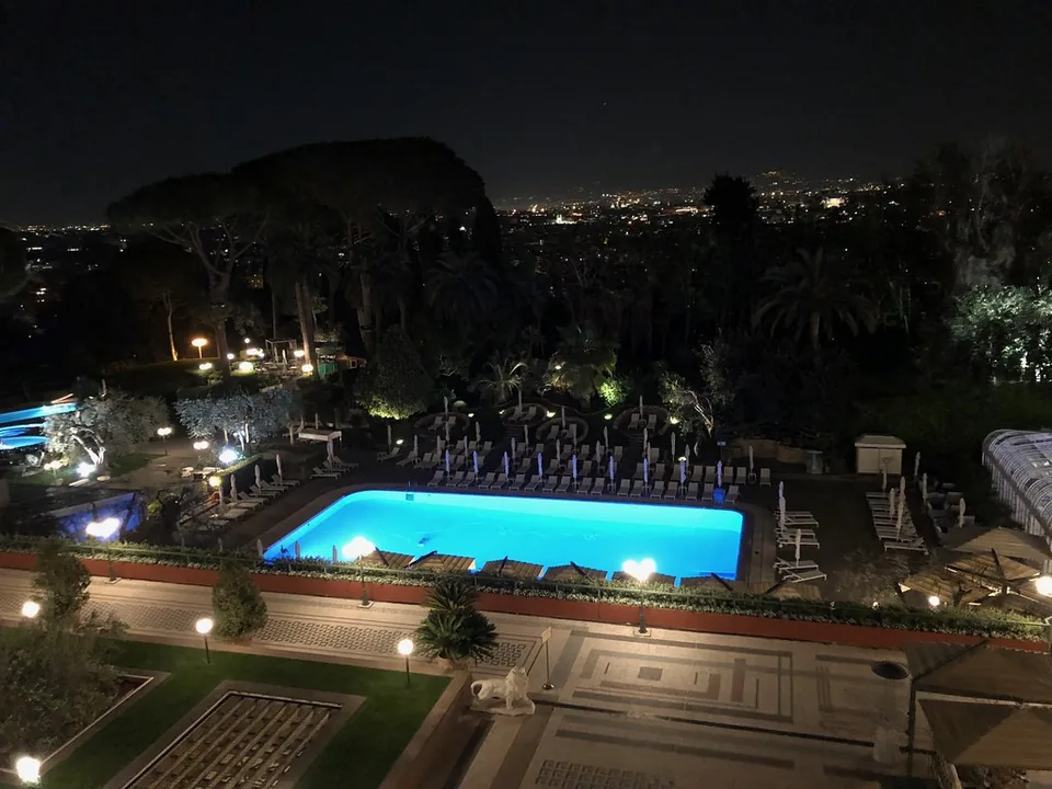 Outdoor pool and gardens at Rome Cavalieri at night, photographed in 2018.